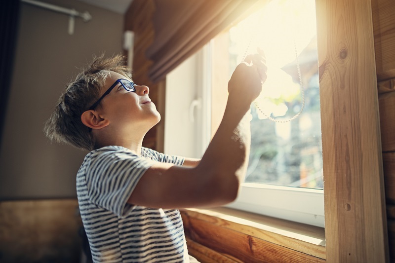 chłopiec zasłanie okno